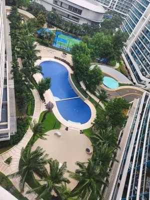 an overhead view of a pool with palm trees and buildings at Azure Staycation Philippines by AMRS Near Manila International Airport in Manila