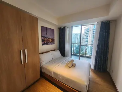 a bedroom with a bed with a teddy bear on it at Azure Staycation Philippines by AMRS Near Manila International Airport in Manila