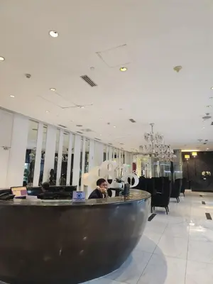 a man sitting at a desk in a lobby at Azure Staycation Philippines by AMRS Near Manila International Airport in Manila