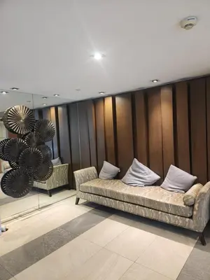 a couch in a room with wooden walls at Azure Staycation Philippines by AMRS Near Manila International Airport in Manila