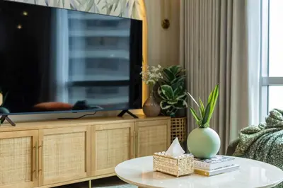 a living room with a tv and a table at Tropical Sunset w the best view in BGC plus Netlfix in Manila