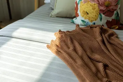 a close up of a bed with a dress on it at Tropical Sunset w the best view in BGC plus Netlfix in Manila