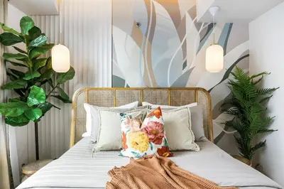 a bed with white sheets and pillows in a room at Tropical Sunset w the best view in BGC plus Netlfix in Manila
