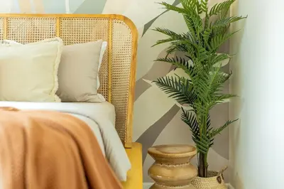 a plant in a vase next to a bed at Tropical Sunset w the best view in BGC plus Netlfix in Manila
