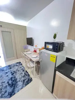 a kitchen with a small table and a refrigerator at Unistay SHORE Residence w Balcony Amazing Manila Bay view near MOA in Manila