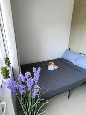 a bed in a room with purple flowers on it at Unistay SHORE Residence w Balcony Amazing Manila Bay view near MOA in Manila