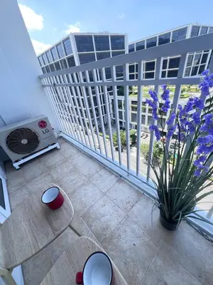 a balcony with a heater and purple flowers on a building at Unistay SHORE Residence w Balcony Amazing Manila Bay view near MOA in Manila