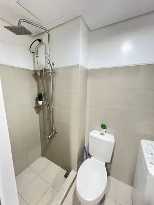a small bathroom with a toilet and a shower at Unistay SHORE Residence w Balcony Amazing Manila Bay view near MOA in Manila