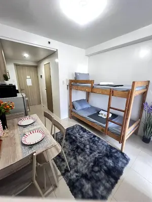 a living room with a table and a bunk bed at Unistay SHORE Residence w Balcony Amazing Manila Bay view near MOA in Manila