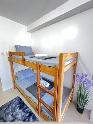 a bunk bed in a room with a plant at Unistay SHORE Residence w Balcon Amazing Manila Bay View in Manila