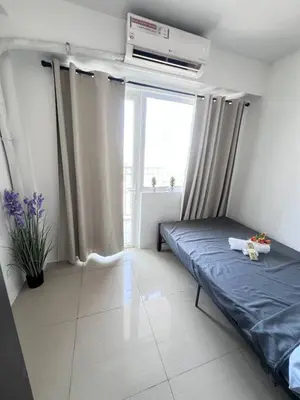 a bedroom with a bed and a window at Unistay SHORE Residence w Balcon Amazing Manila Bay View in Manila