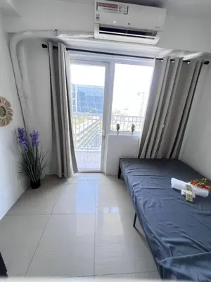 a bedroom with a bed and a large window at Unistay SHORE Residence w Balcon Amazing Manila Bay View in Manila