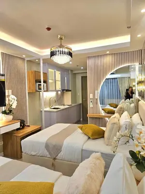 a large bedroom with two beds and a kitchen at Serenity Suite in Manila