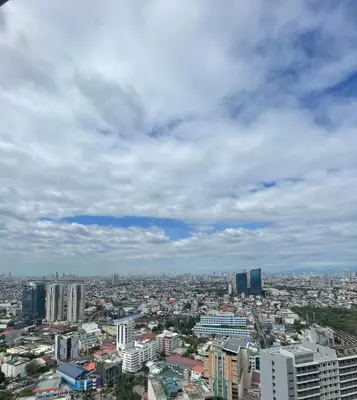 a view of a city under a cloudy sky at 1 BR Condo w Balcony in Air Residence Makati in Manila