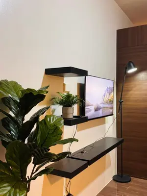 a flat screen tv on a wall with a plant at 1 BR Condo w Balcony in Air Residence Makati in Manila