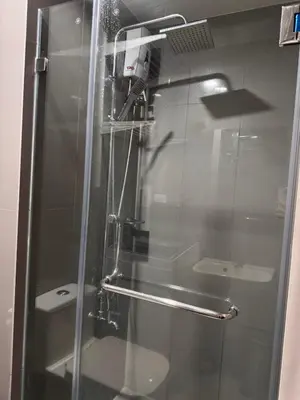 a shower with a glass door in a bathroom at 1 BR Condo w Balcony in Air Residence Makati in Manila