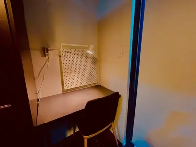 a desk in the corner of a room with a chair at 1 BR Condo w Balcony in Air Residence Makati in Manila