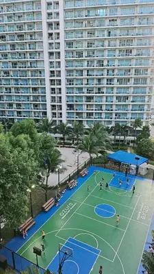 a tennis court in front of a large building at Cozy Apartment Azure Urban Resort Residences in Manila