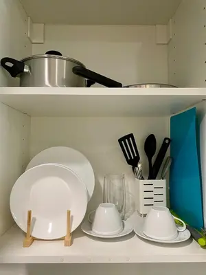 a shelf with plates and utensils on it at Condo unit near SM City Sta Rosa Unit 2 in Ibaba