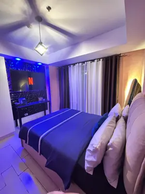 a bedroom with a large bed and a television at Azure Urban Resort Residences - Staycationary Miami 1710 in Manila