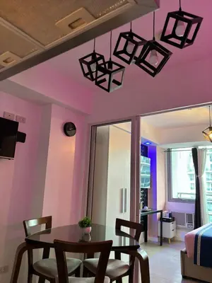 a dining room with pink walls and a table and chairs at Azure Urban Resort Residences - Staycationary Miami 1710 in Manila