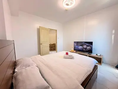 a bedroom with a large bed and a flat screen tv at Malate Bayview Mansion Korean Town 1Bedroom in Manila