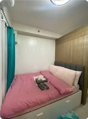 a bed with a pink comforter in a room at Modern Comfort at Shore 2 MOA in Manila