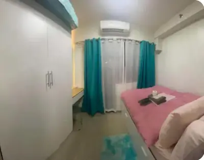 a bedroom with a pink bed and green curtains at Modern Comfort at Shore 2 MOA in Manila