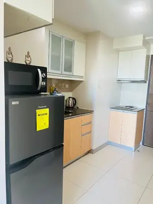 a kitchen with a refrigerator with a yellow sign on it at BGC Simple Elegant 300Mbps Wifi,Pool,Netflix in Manila