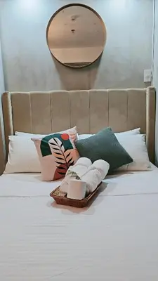 a tray of towels on a bed with a mirror at Cozy Apartment Azure Urban Resort Residences in Manila