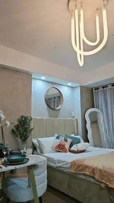 a bedroom with a bed and a table and a mirror at Cozy Apartment Azure Urban Resort Residences in Manila