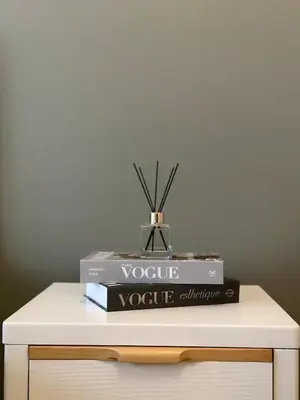 two books on a table with a vase on top at King Size 3-Bedroom in Uptown Parksuites BGC in Manila