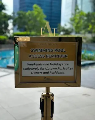a sign for a swimming pool access remoter on a pole at King Size 3-Bedroom in Uptown Parksuites BGC in Manila