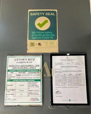 two signs on a wall with asafety seal and asafety seat at King Size 3-Bedroom in Uptown Parksuites BGC in Manila