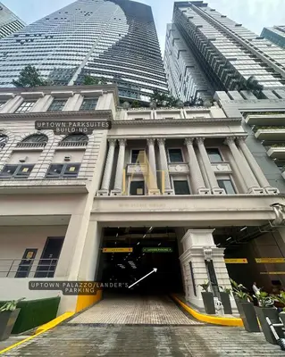 a large building with a doorway in front of two tall buildings at King Size 3-Bedroom in Uptown Parksuites BGC in Manila