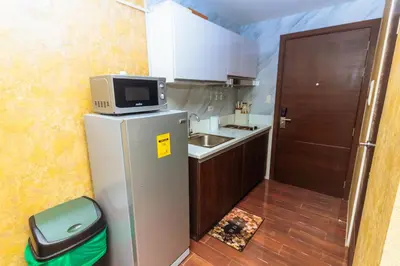 a small kitchen with a refrigerator and a microwave at City of Dreams Luxury Makati 5637 Swim Gym Netflix Superfast Surfing in Manila