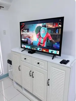 a flat screen tv on top of a white entertainment center at Torre de manila taft 23 in Manila