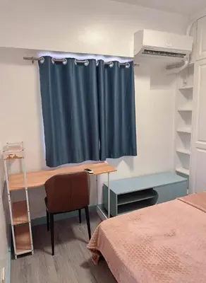a room with a desk and a blue curtain at Torre de manila taft 23 in Manila