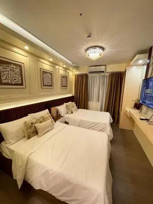 a hotel room with two beds and a television at Belfort Suite by Crib2GO in Manila