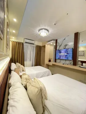 a hotel room with two beds and a tv at Belfort Suite by Crib2GO in Manila