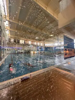 a large swimming pool with people swimming in it at Cozy Laura at ACE Plaza in Manila