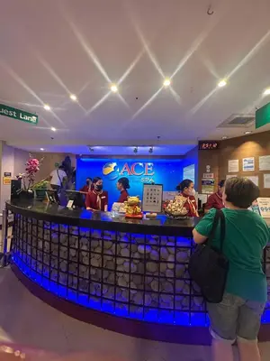 a group of people standing at a bar in a store at Cozy Laura at ACE Plaza in Manila