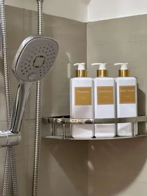 a shelf with four bottles of soap on it in a bathroom at Casa y' Bonita MOA Pasay Staycation in Manila