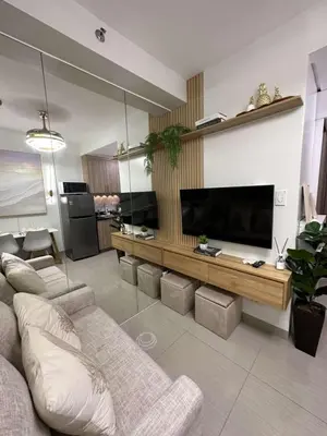 a living room with a couch and a large television at Casa y' Bonita MOA Pasay Staycation in Manila