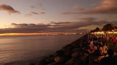 a crowd of people sitting on a pier near the water at Casa y' Bonita MOA Pasay Staycation in Manila