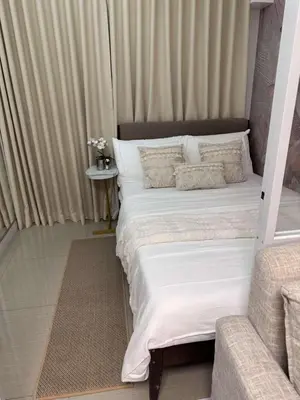a bedroom with a large bed with white sheets and pillows at Casa y' Bonita MOA Pasay Staycation in Manila
