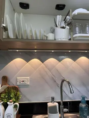 a kitchen counter with a sink and plates on a shelf at Casa y' Bonita MOA Pasay Staycation in Manila