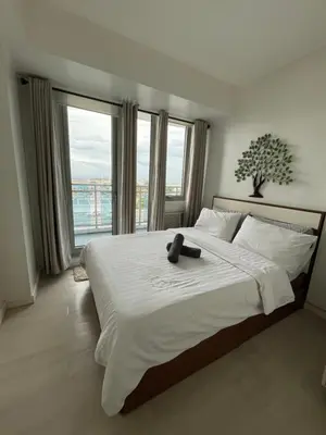 a bedroom with a large bed with a teddy bear on it at Azure Condo Maui by arlene in Manila