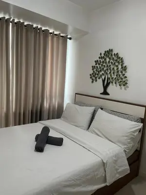 a bed with a hat sitting on top of it at Azure Condo Maui by arlene in Manila