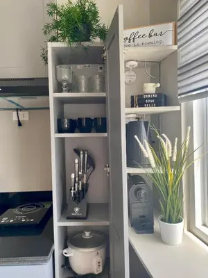 a kitchen cabinet filled with lots of kitchen utensils at The Carly Suite in Manila